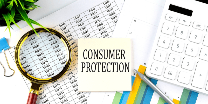 電卓や数字が記載された紙の上に「consumer protection」という文字の画像